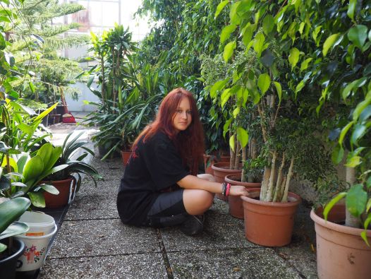 Eine Schülerin pflegt Topfpflanzen