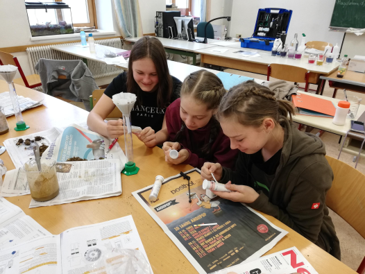 Drei Schülerinnen erforschen im Bodenlabor Mikroorganismen
